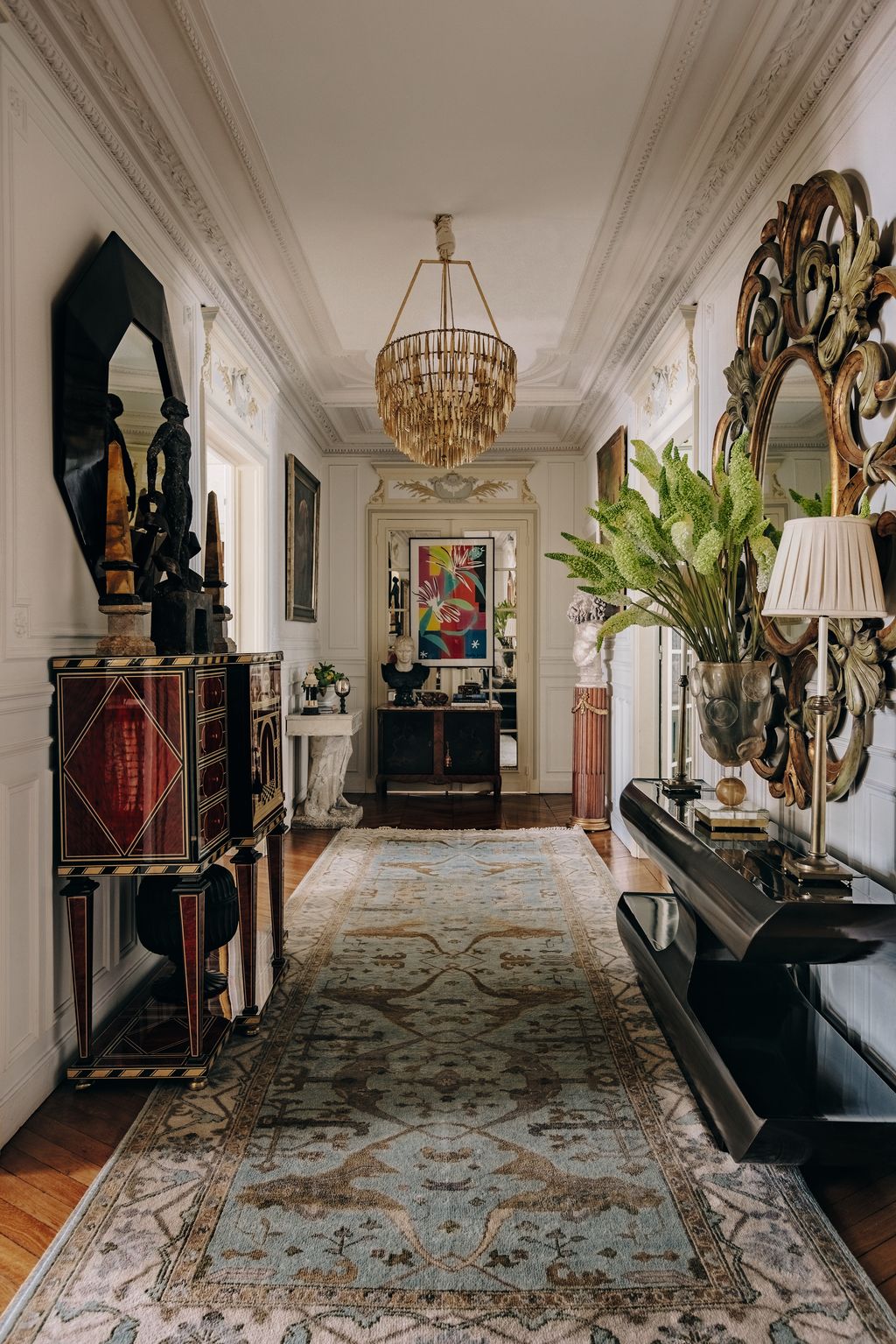 Image may contain Home Decor Rug Indoors Art Painting Person Lamp Plant Architecture Building and Foyer