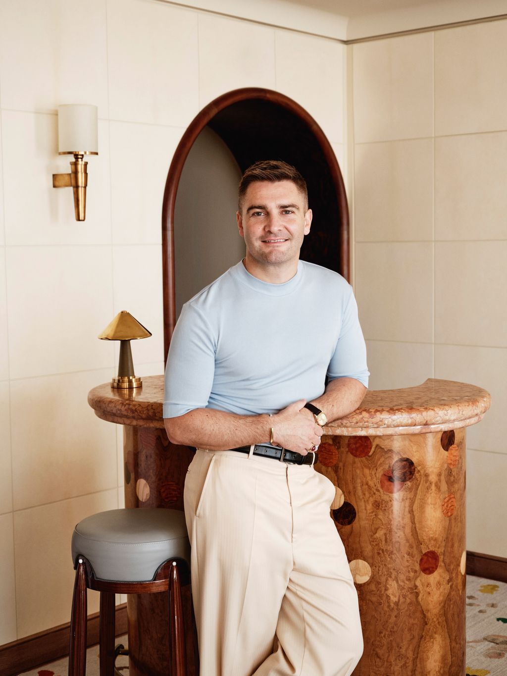 Image may contain Adult Person Accessories Belt Wristwatch Wood Sitting Lamp Face Head Photography and Portrait