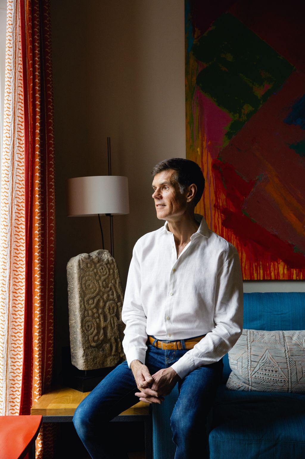 Image may contain Person Sitting Adult Accessories Belt Lamp Clothing Pants Couch and Furniture