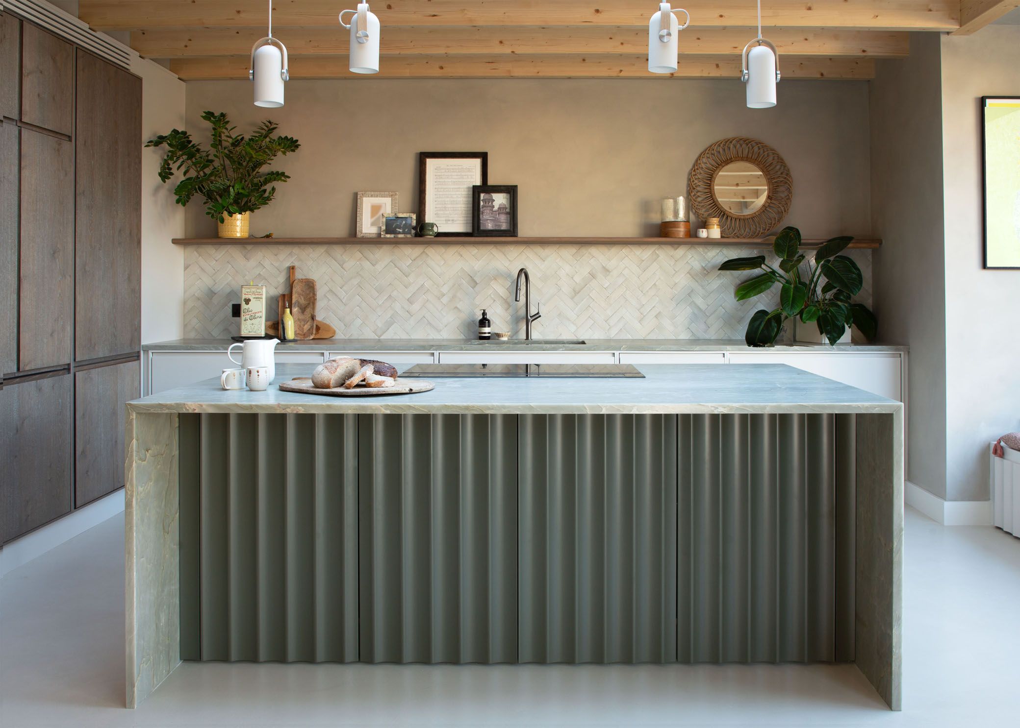 Image may contain: Indoors, Interior Design, Kitchen, Plant, Lamp, Kitchen Island, Sink, Sink Faucet, Art, and Painting