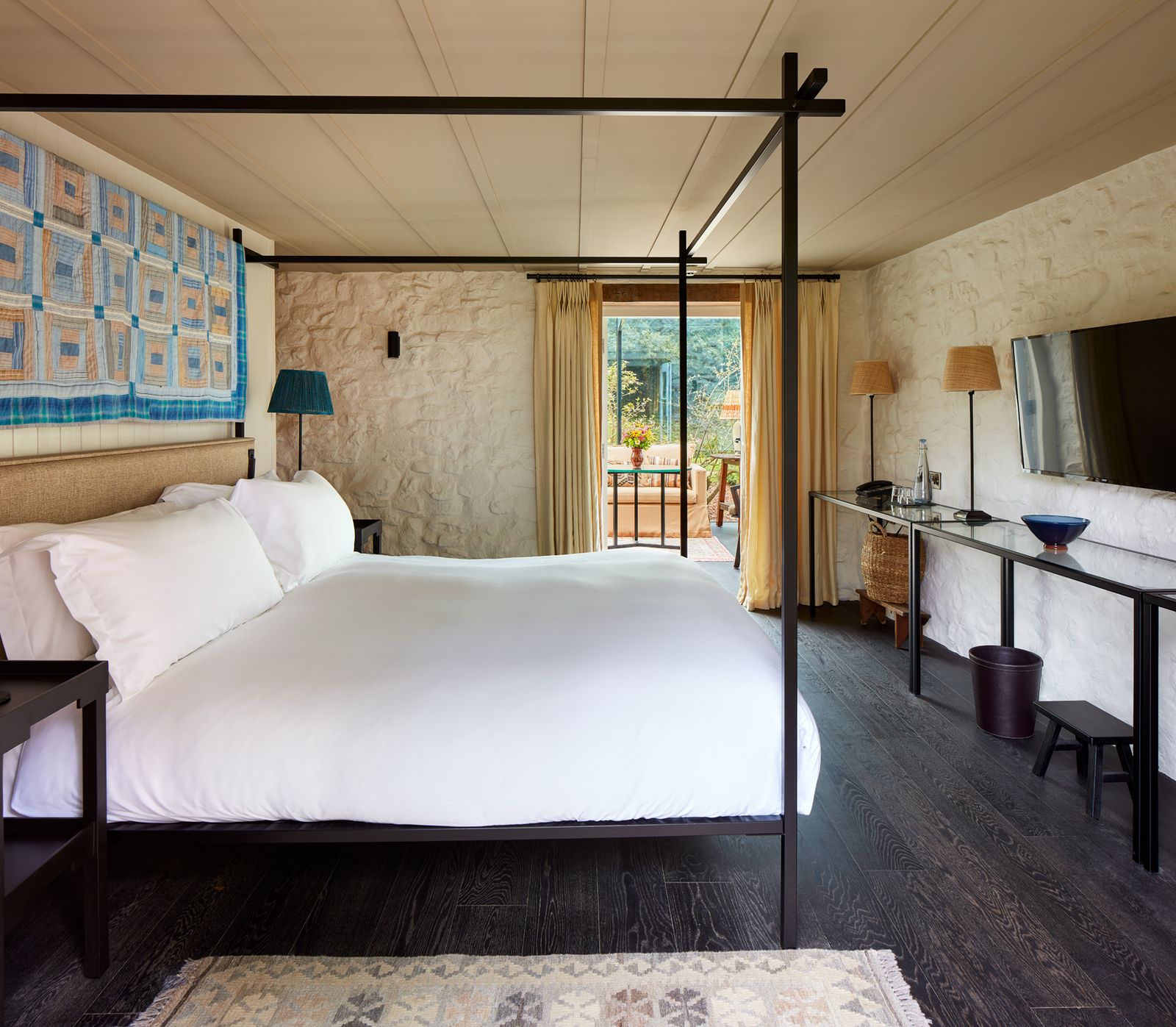 Image may contain Furniture Bed Bedroom Indoors Room Lamp Home Decor Rug Desk Table Plant and Canopy Bed