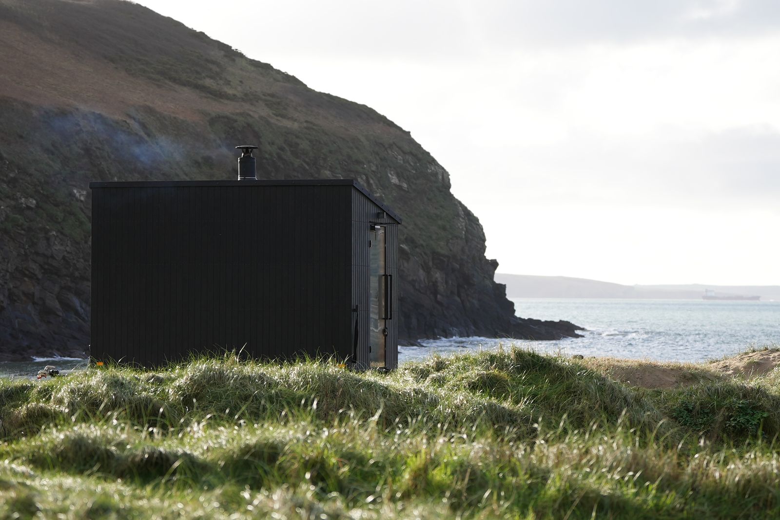 Image may contain Architecture Building Outdoors Shelter Countryside Hut Nature Rural Shack Scenery Sea and Water