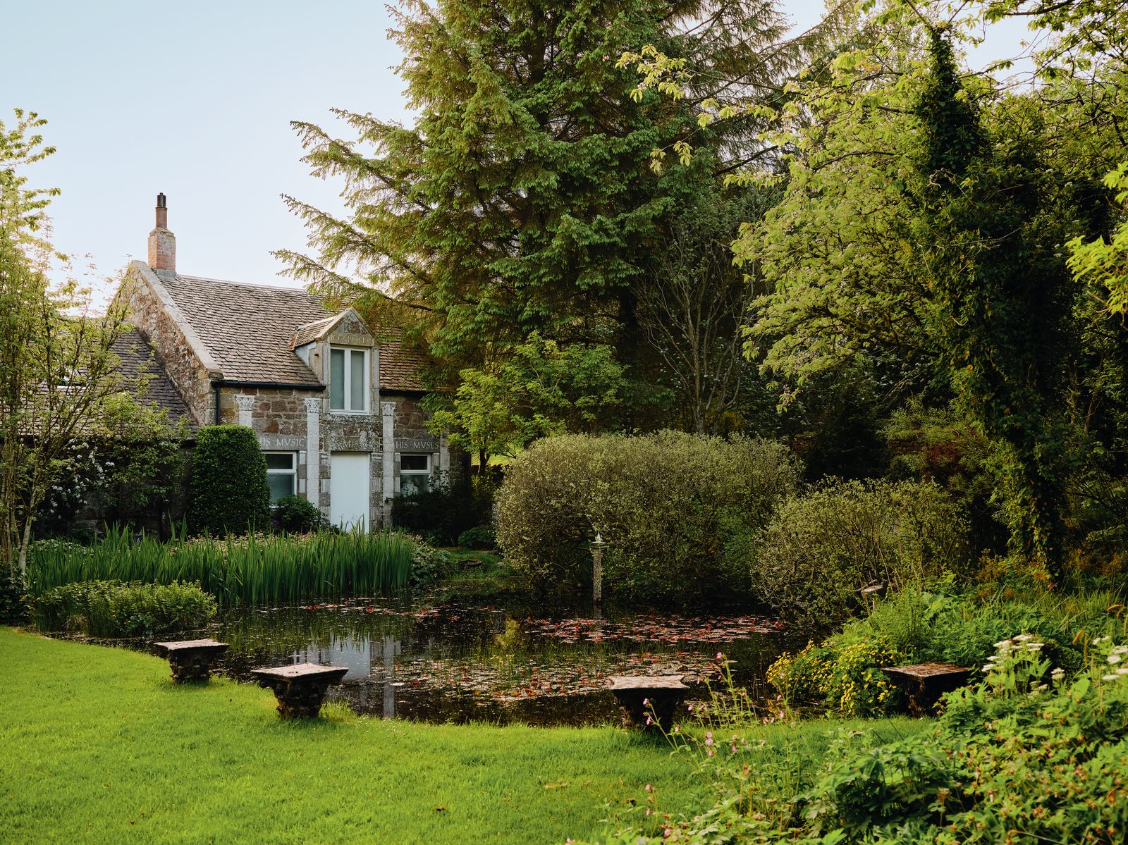 Image may contain Architecture Building Cottage House Housing Grass Plant Nature Outdoors Pond Water and Garden