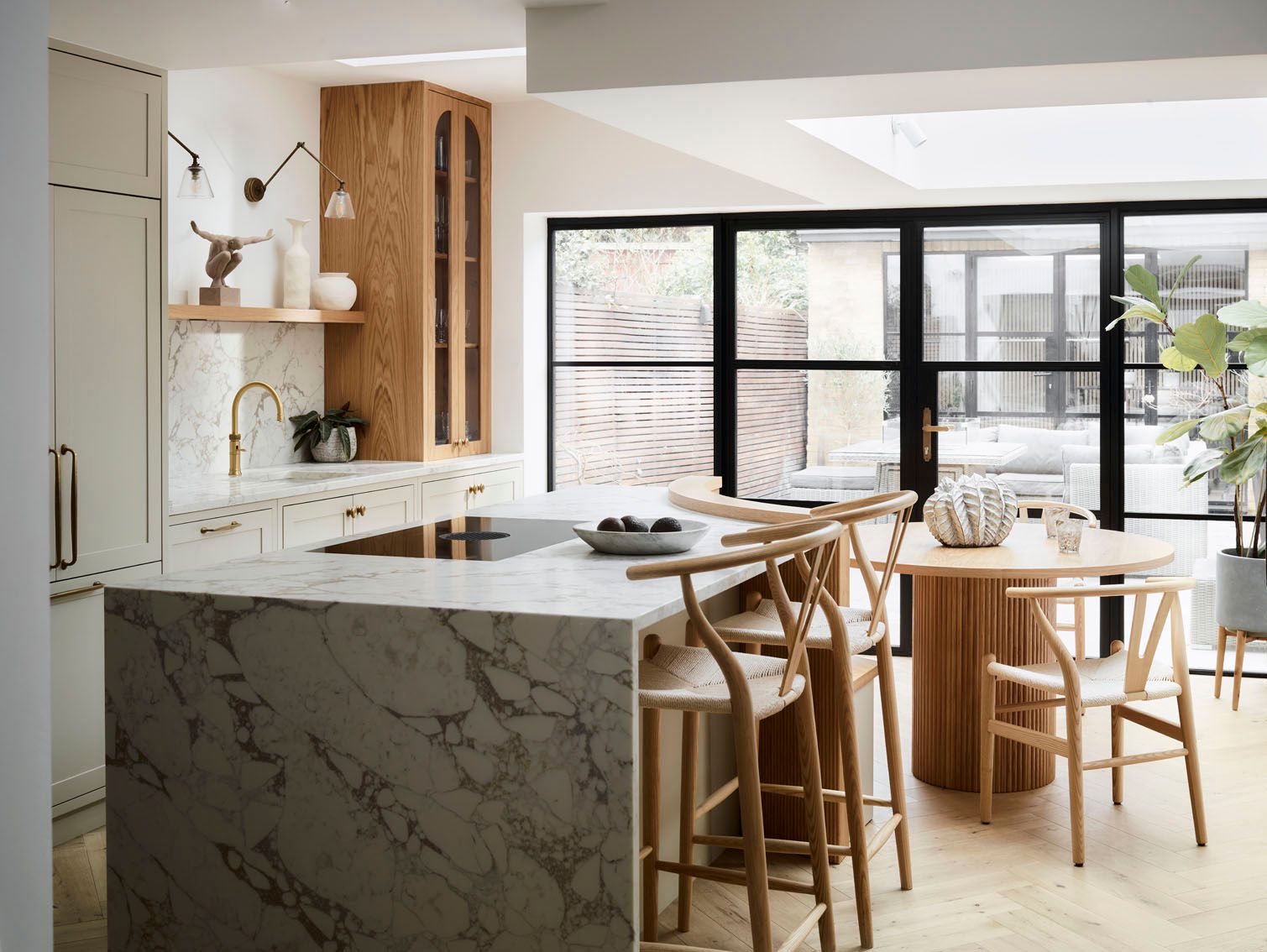 Image may contain: Indoors, Interior Design, Kitchen, Kitchen Island, Chair, Furniture, Plant, Plate, Person, and Cup