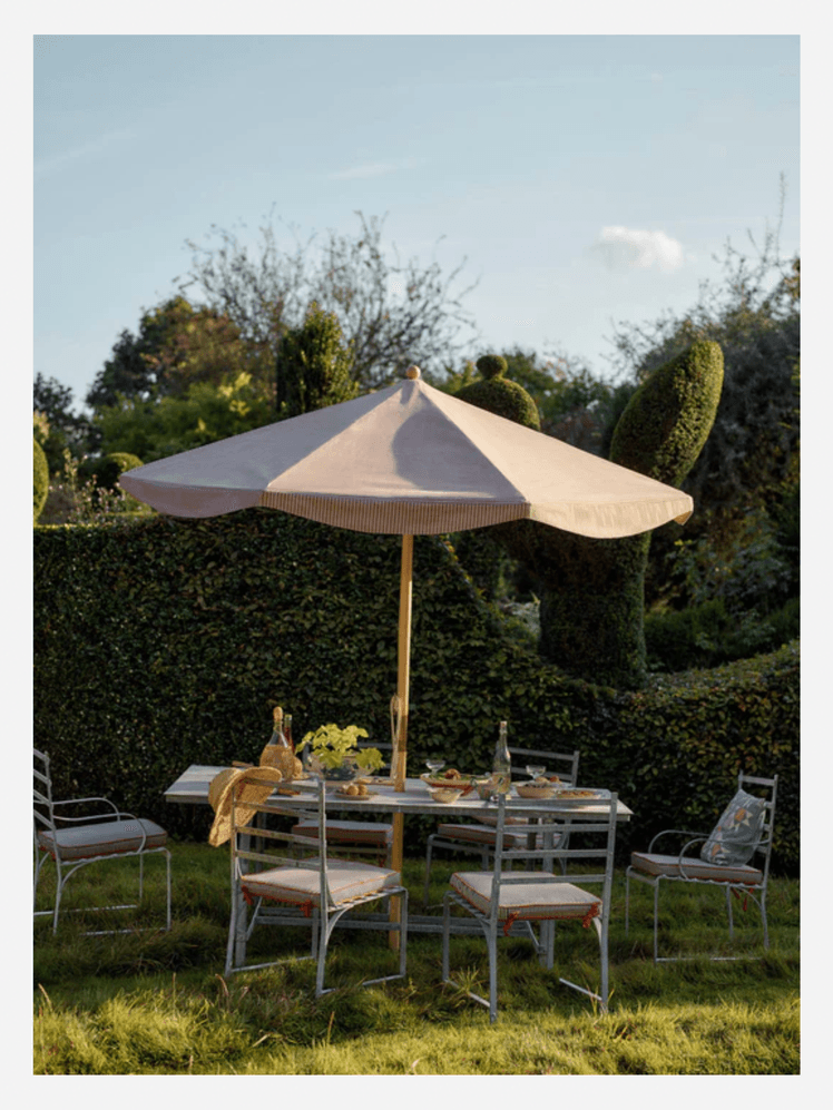 Image may contain: Architecture, Building, House, Housing, Patio, Grass, Plant, Patio Umbrella, Chair, Furniture, and Table