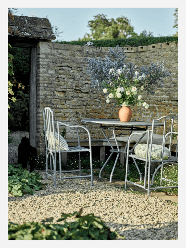 Image may contain: Chair, Furniture, Dining Table, Table, Gravel, Road, Backyard, Nature, Outdoors, Yard, and Architecture