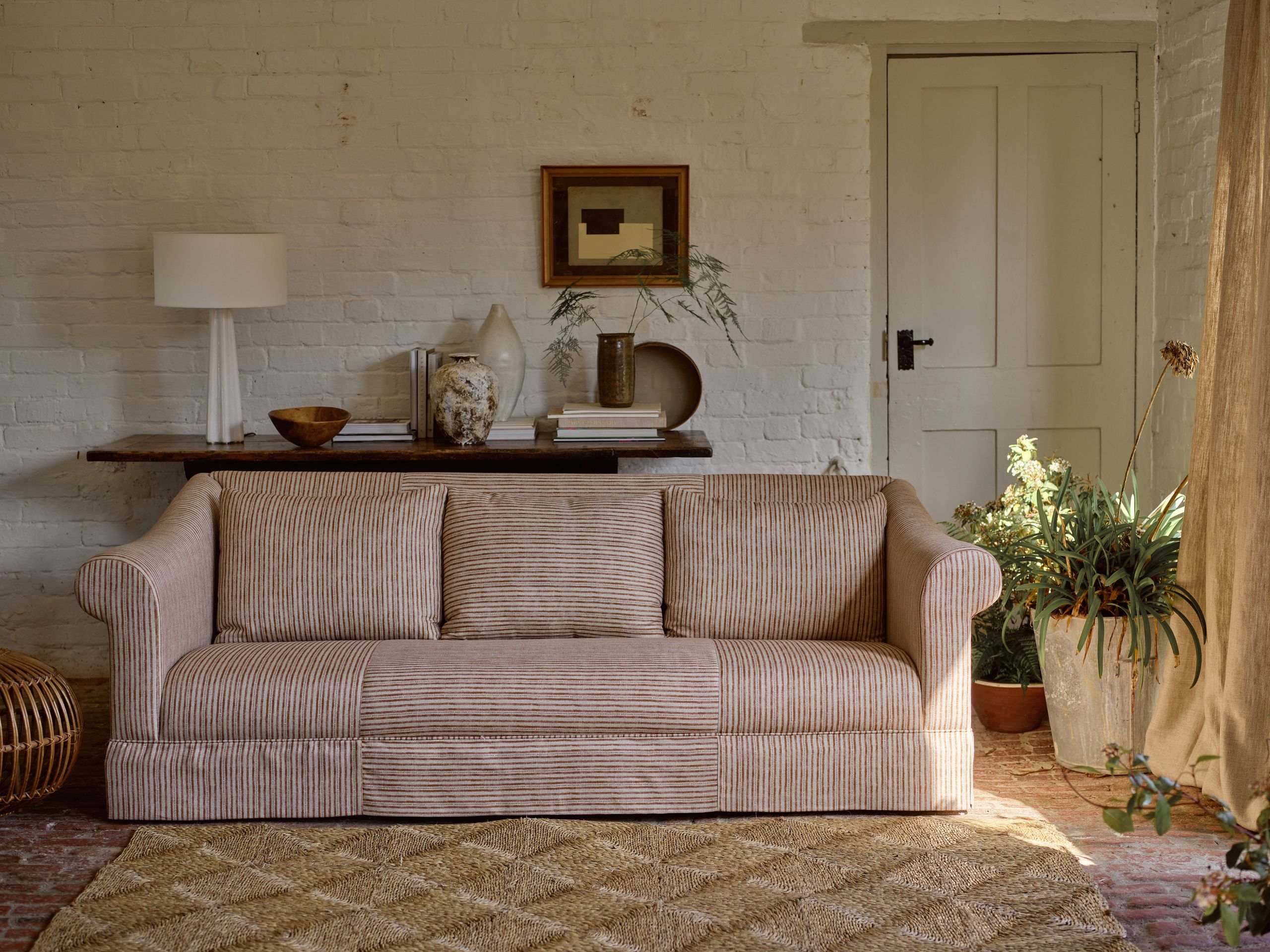 Image may contain: Home Decor, Couch, Furniture, Cushion, Indoors, Interior Design, Lamp, Rug, Pillow, Art, and Painting