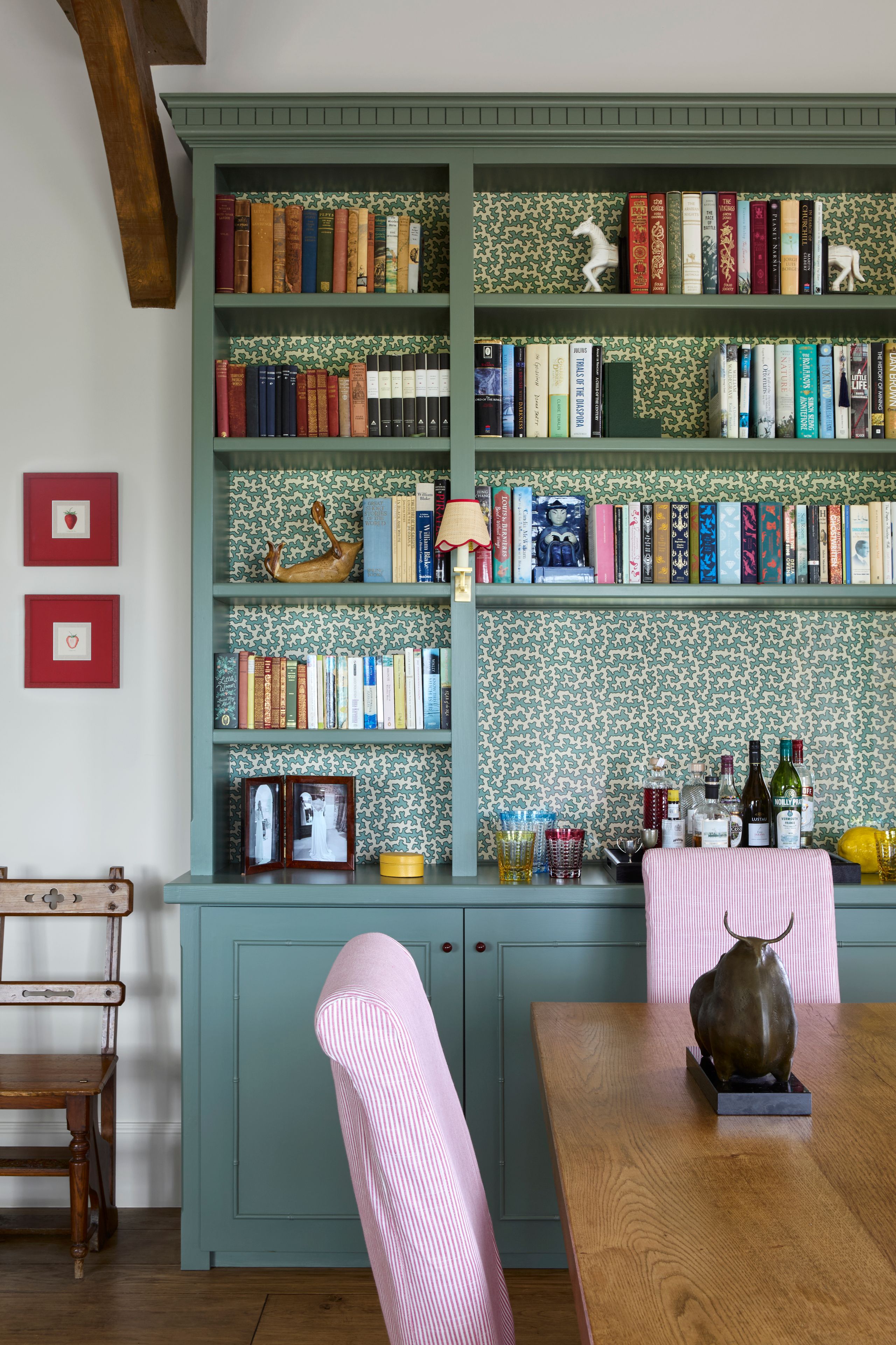 Image may contain: Furniture, Bookcase, Cup, Chair, Person, Art, Painting, and Candle