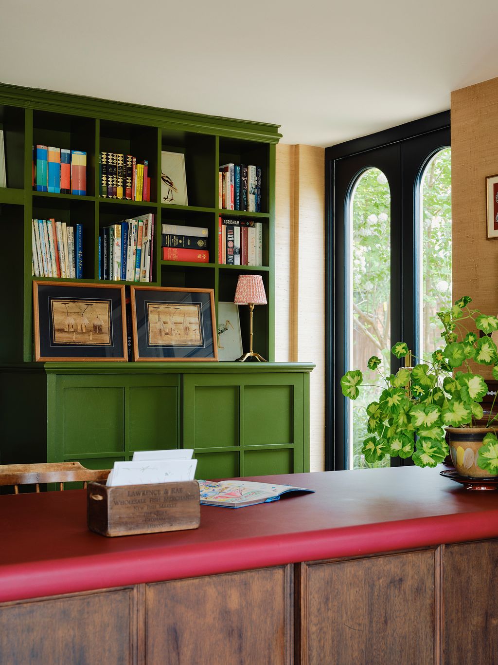 Image may contain Lamp Furniture Indoors Interior Design Art Painting Bookcase Chair and Table