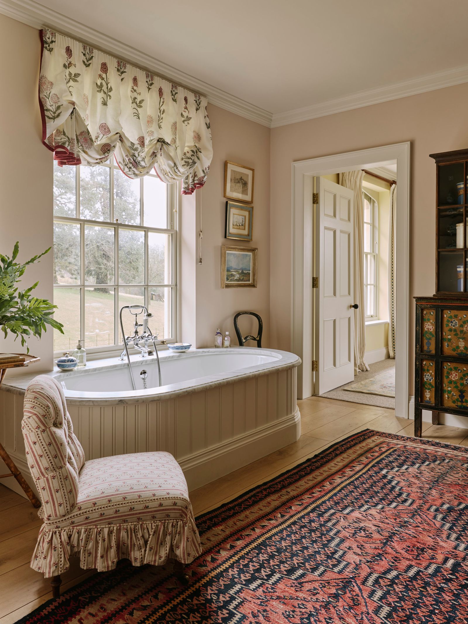 Image may contain Home Decor Indoors Interior Design Chair Furniture Bathing Art Painting Rug Bathtub and Person