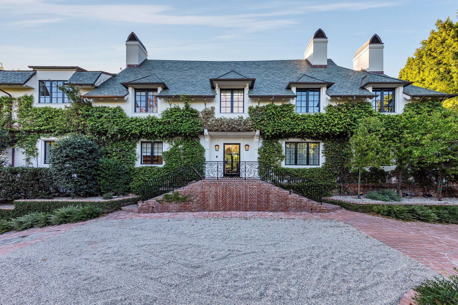 a white brick home with vines covering the sides