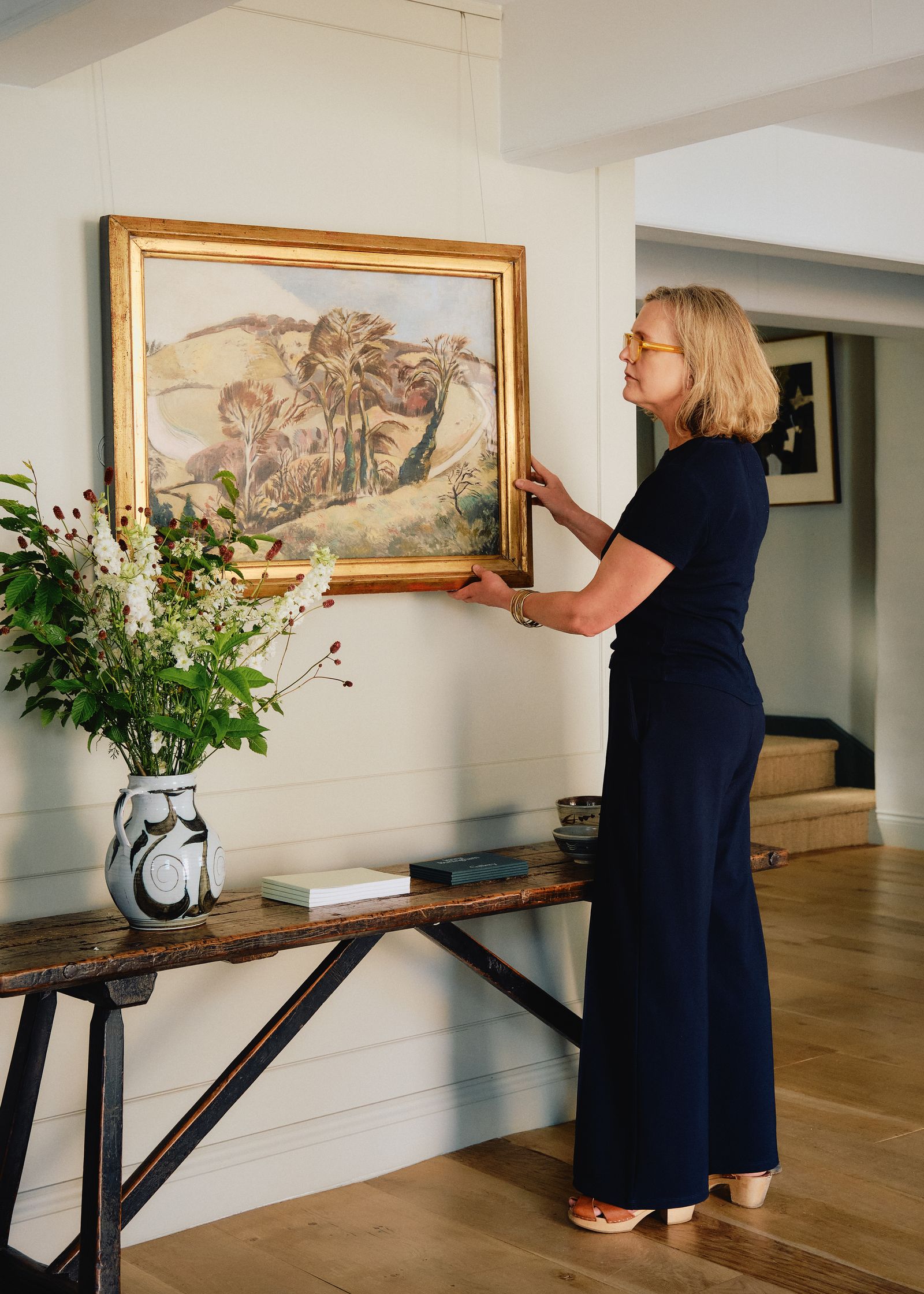 Image may contain Gro Dahle Furniture Table Plant Potted Plant Adult Person Book Publication Desk and Art