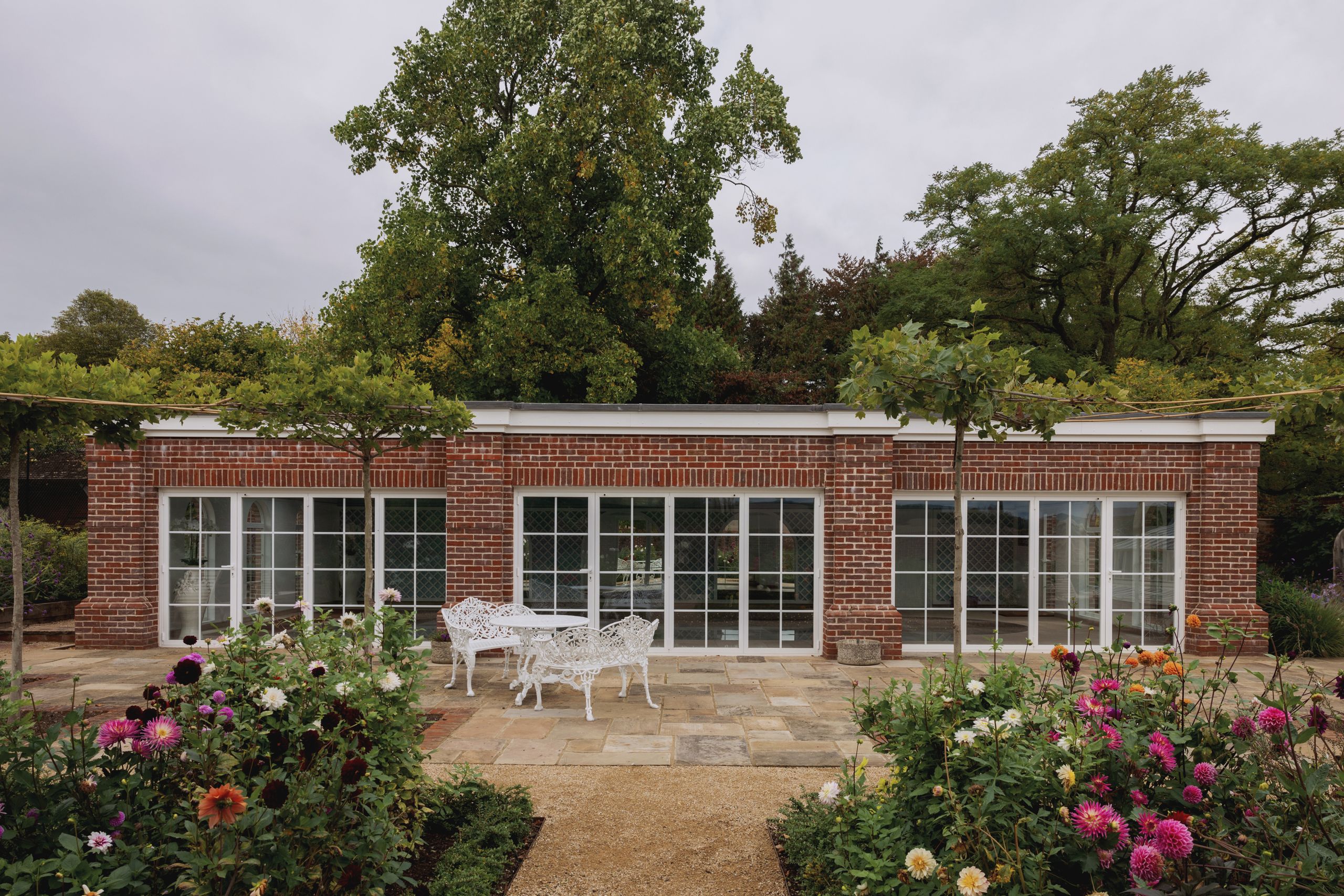 Image may contain: Door, Garden, Nature, Outdoors, Grass, Plant, Potted Plant, Vegetation, Chair, Furniture, and Architecture