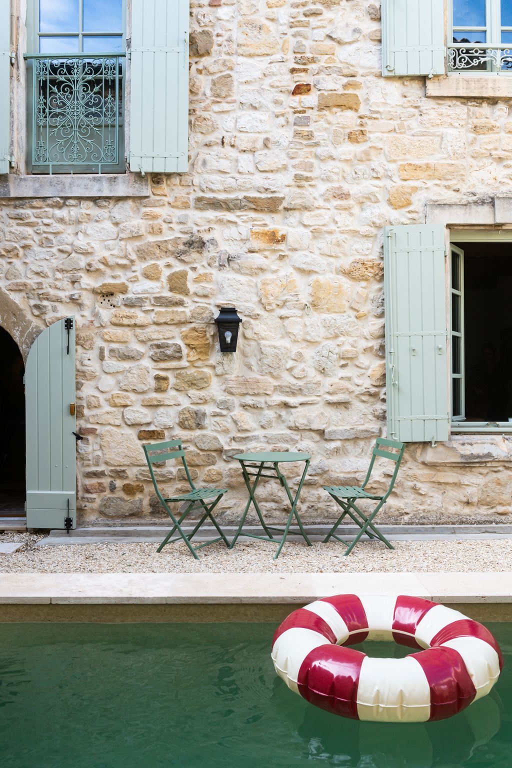 Image may contain Chair Furniture Architecture Building Wall Outdoors Shelter Lamp Water Desk Table and Path