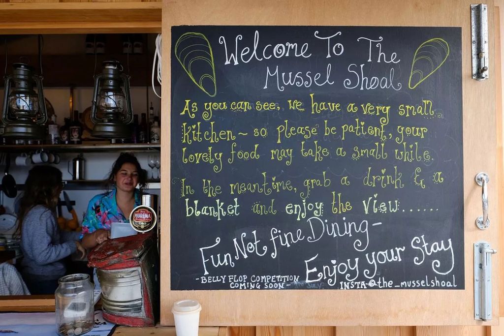 Image may contain Adult Person Blackboard Text and Cup