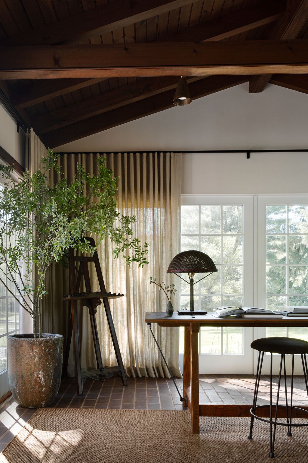 Image may contain Indoors Interior Design Lamp Plant Desk Furniture Table Home Decor Rug and Window