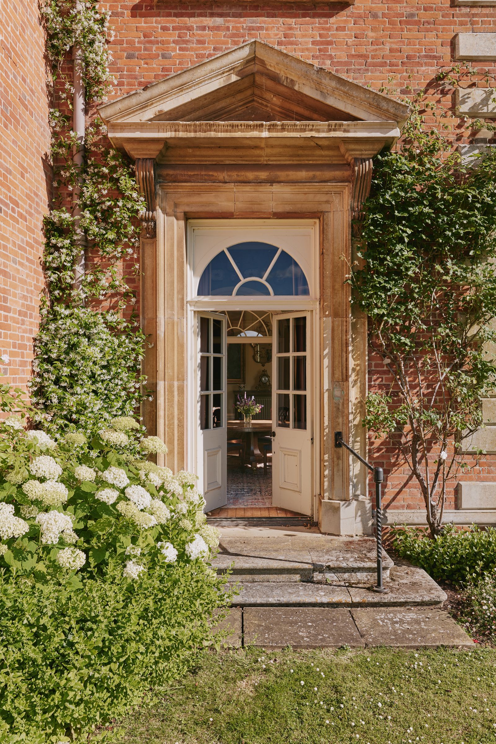 Image may contain Architecture Building Housing House Portico Desk Furniture Table Door and Chair