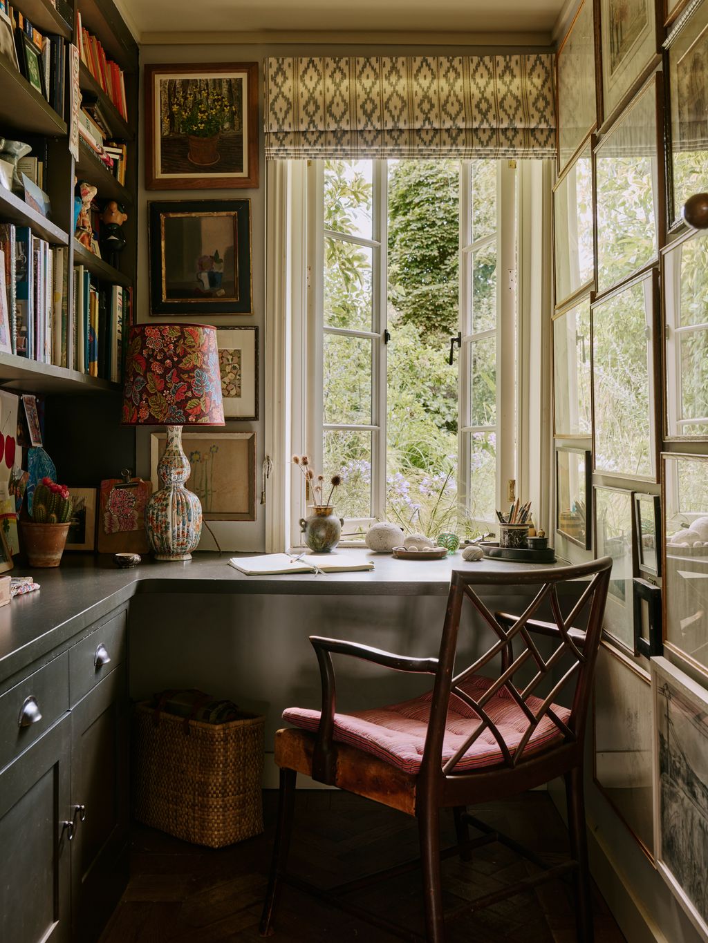 Image may contain Book Publication Lamp Chair Furniture Window Art Painting Bay Window Cup Person and Accessories