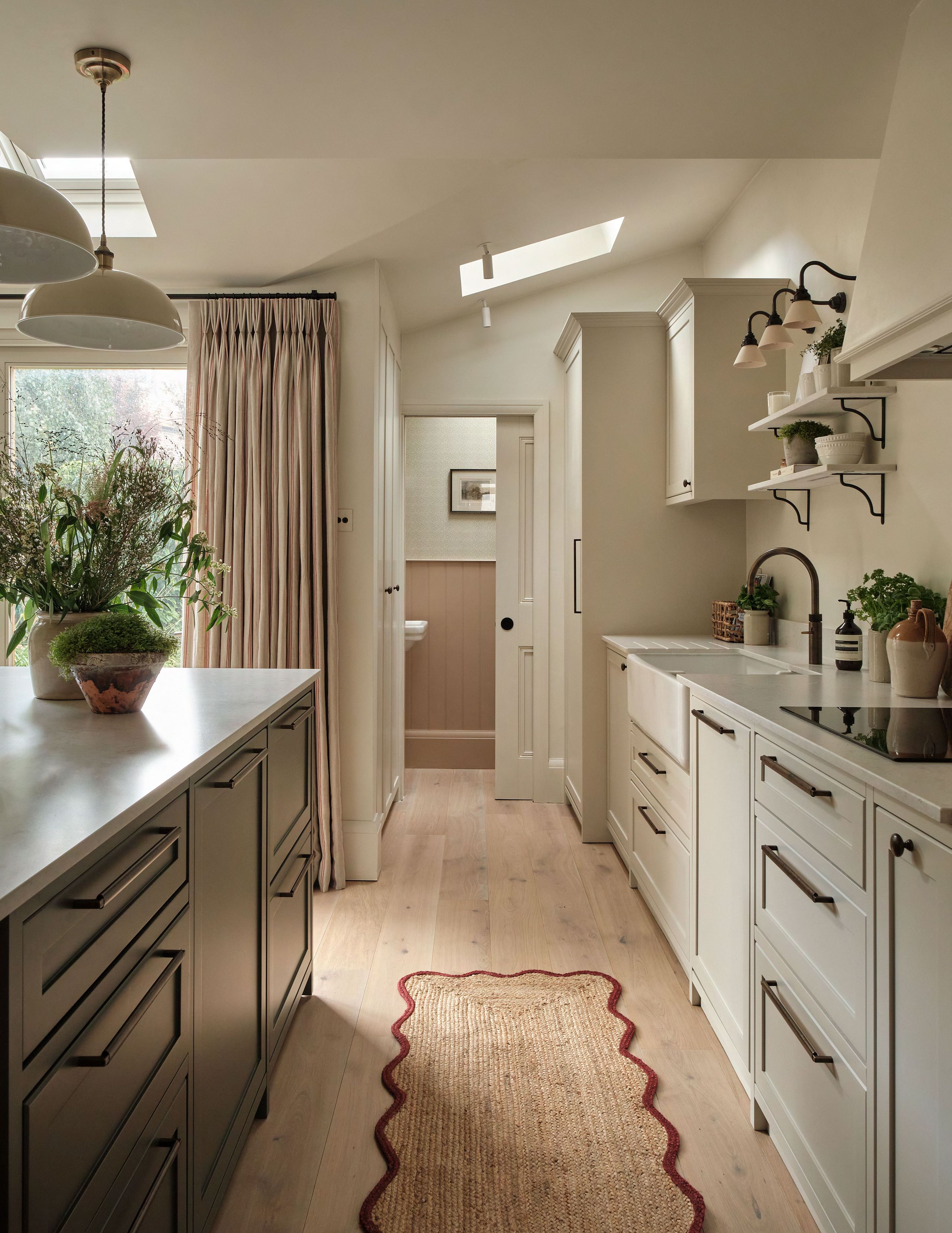 Image may contain: Home Decor, Lamp, Indoors, Interior Design, Plant, Rug, Art, Painting, Cooktop, Kitchen, and Sink