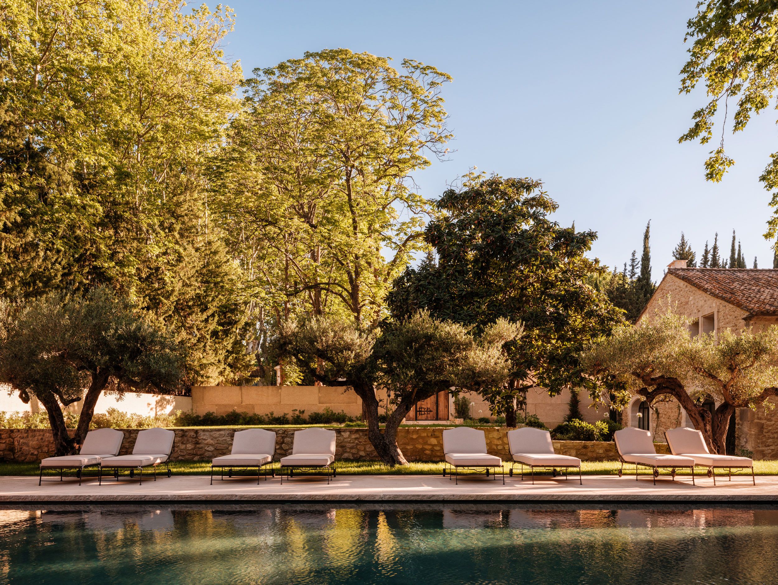 Image may contain: Nature, Outdoors, Scenery, Chair, Furniture, Architecture, Building, Hotel, Resort, Pool, Water, and Grass