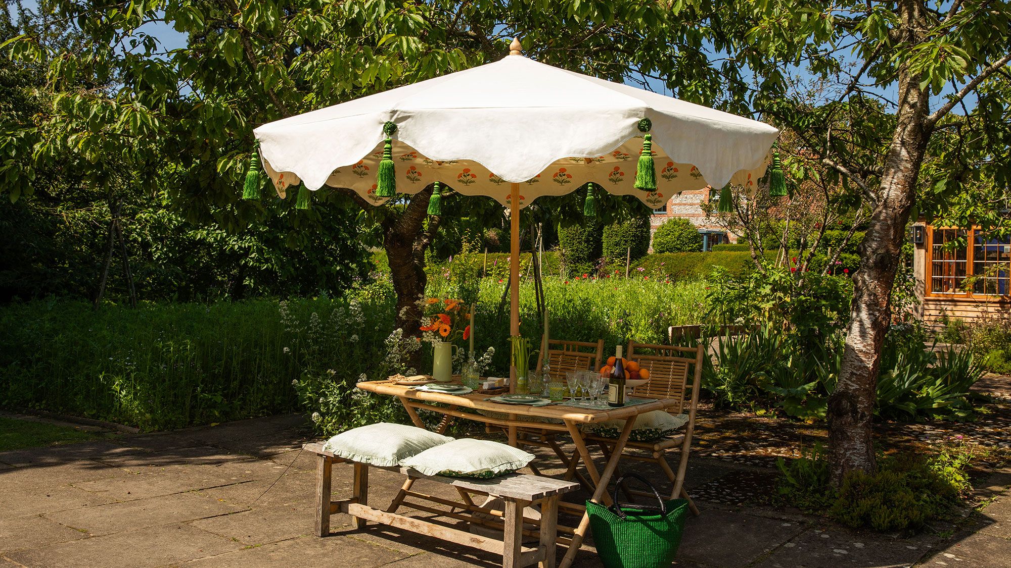 Image may contain: Architecture, Building, House, Housing, Patio, Grass, Plant, Bench, Furniture, Garden, and Nature