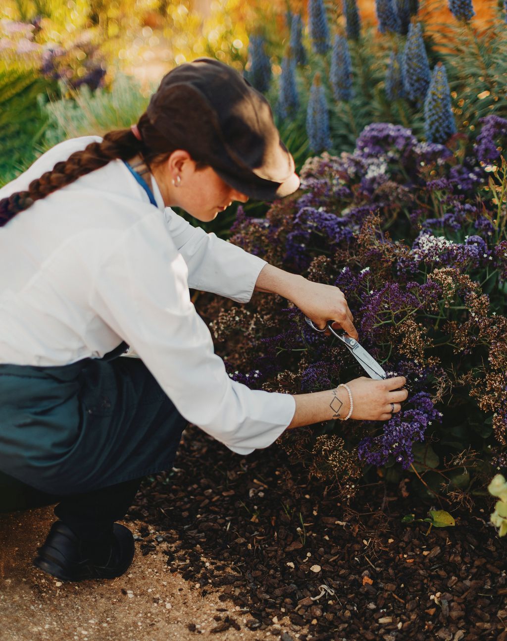 Image may contain Garden Nature Outdoors Gardening Braid Hair Person Clothing Footwear Shoe Gardener and Hat