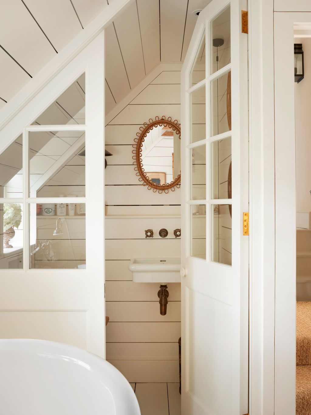 Image may contain Indoors Interior Design Sink Door Wood Panels Bathing Bathtub Person Tub and Architecture