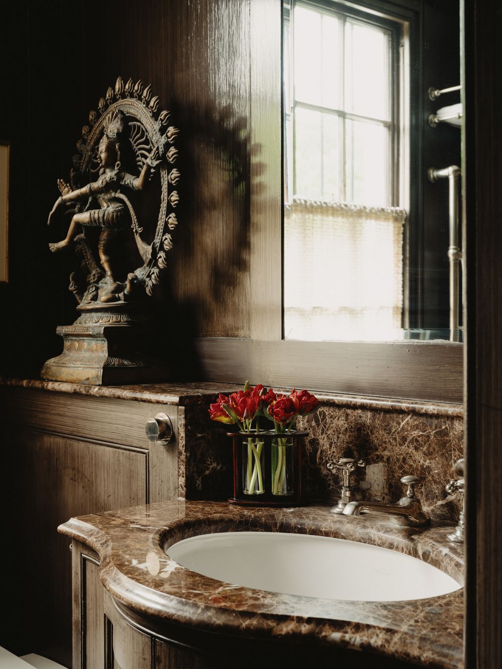 Image may contain Sink Sink Faucet Person Indoors Interior Design Bronze Flower Plant and Flower Arrangement