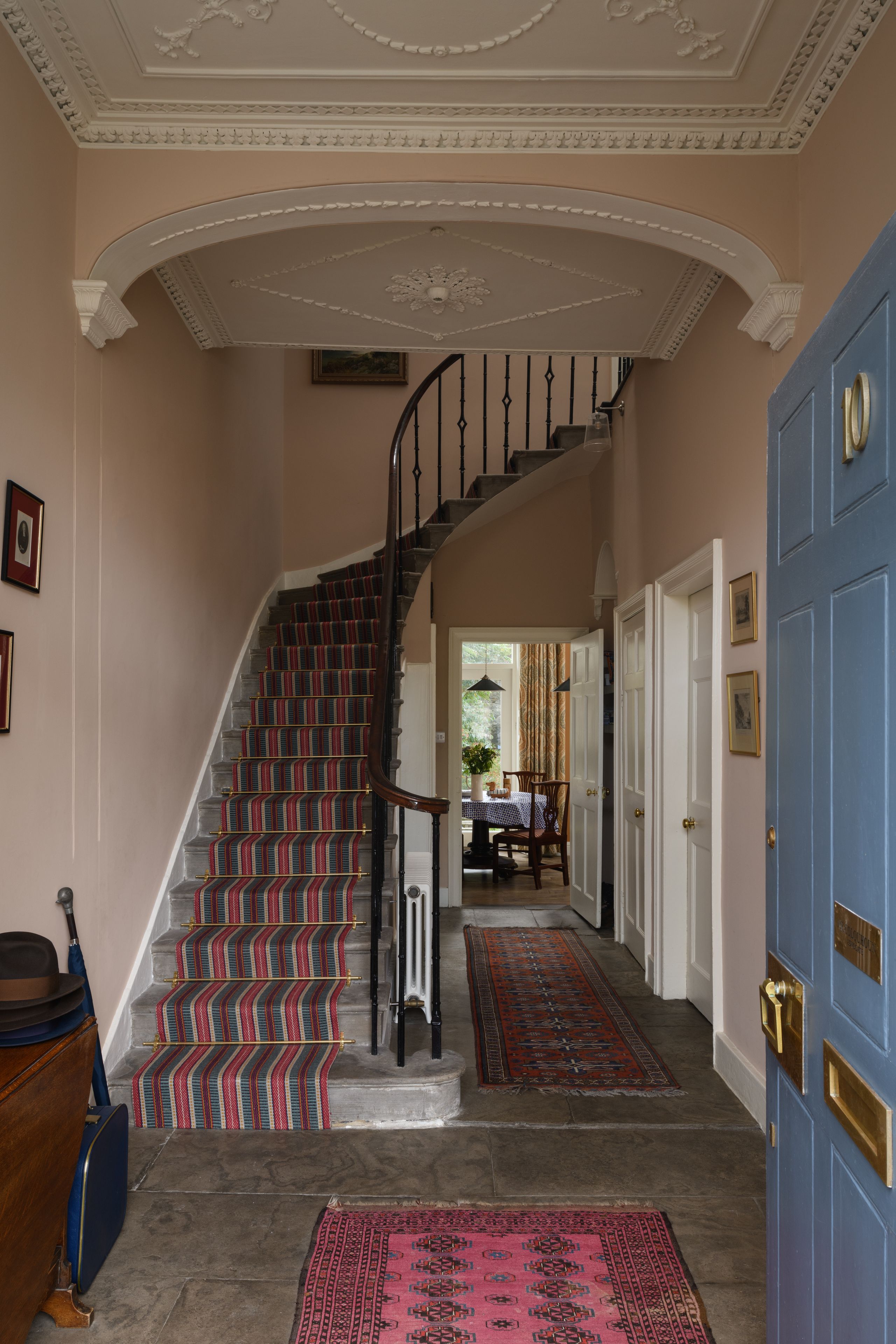 Image may contain: Indoors, Architecture, Building, Foyer, Home Decor, Rug, Chair, Furniture, Art, Painting, and Plant