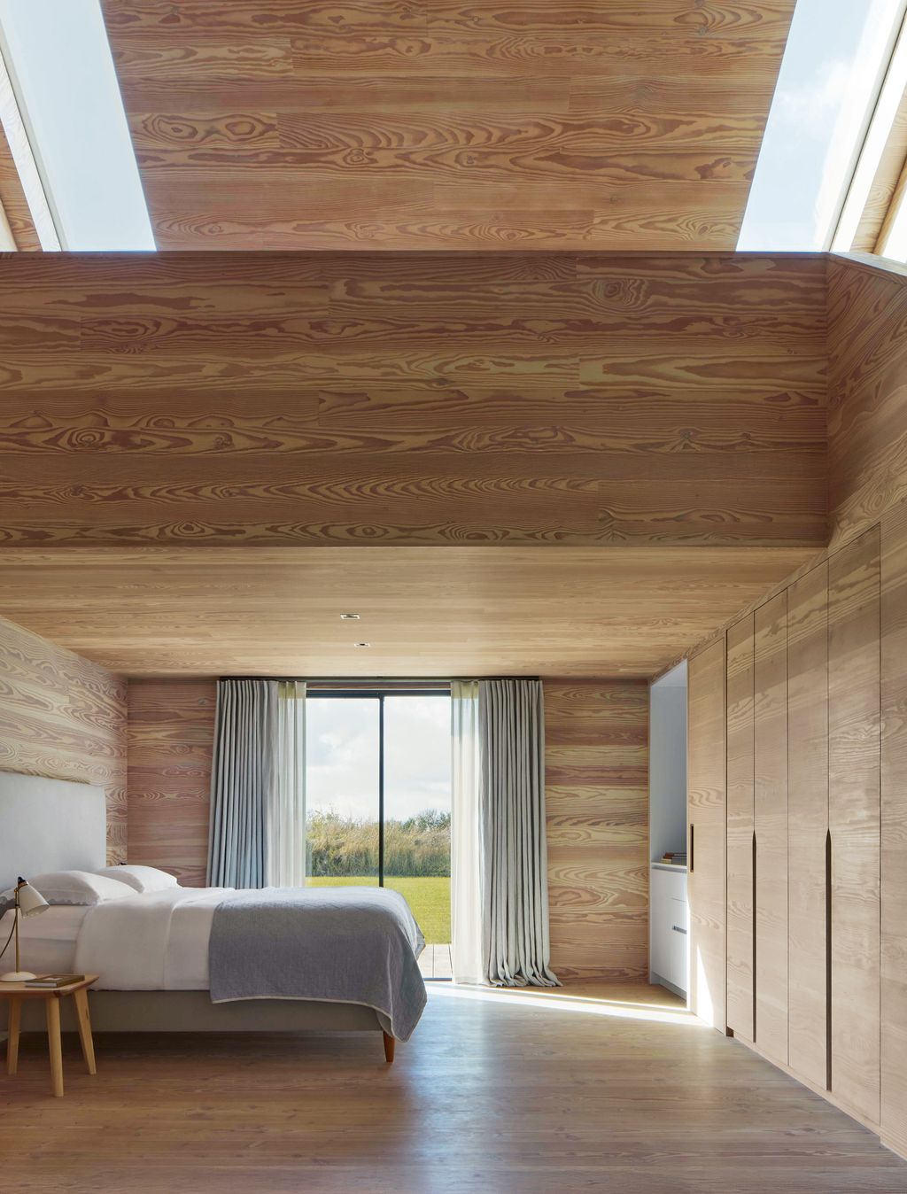 Image may contain Indoors Interior Design Wood Wood Panels Lamp Hardwood Stained Wood Bed Furniture Desk and Table