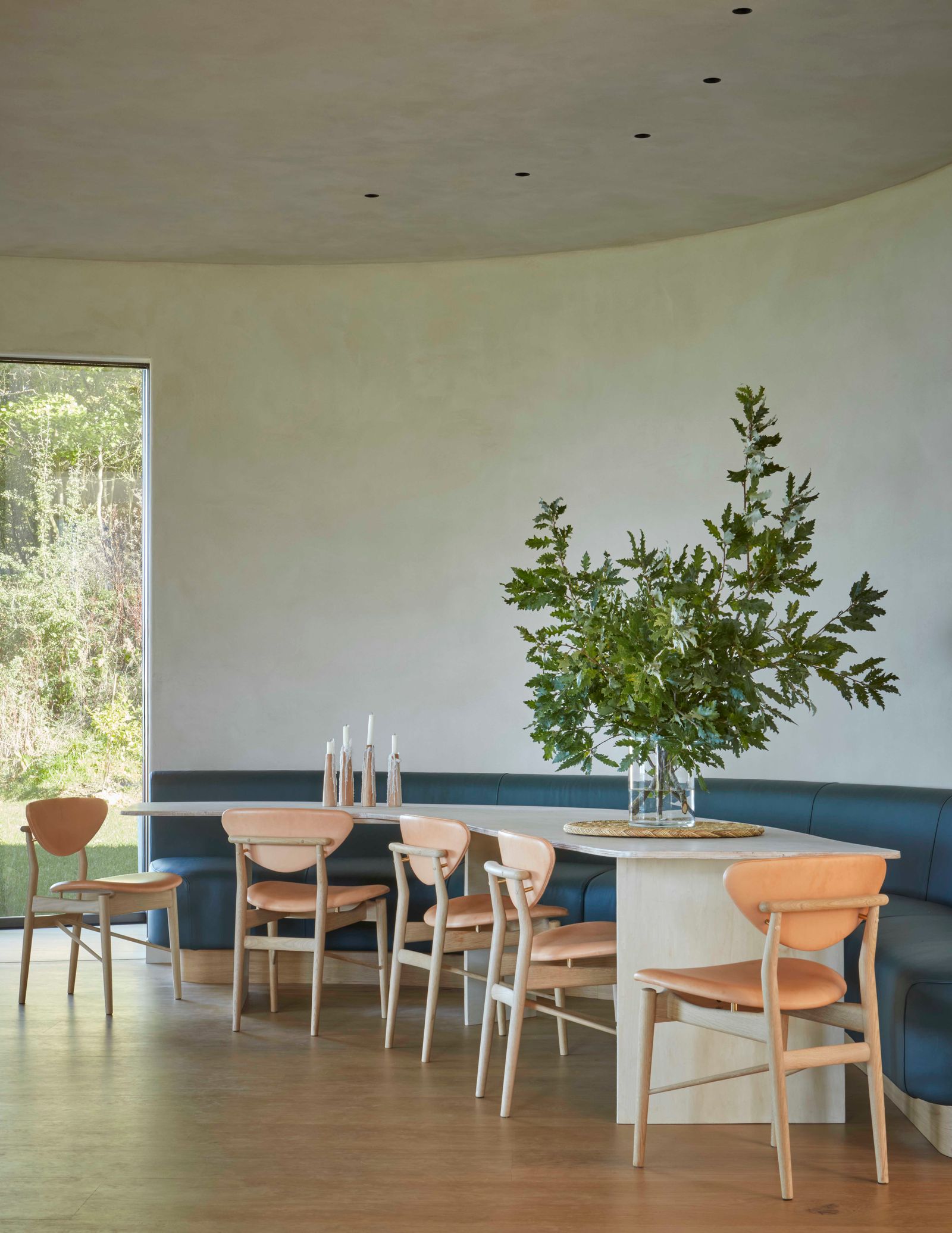 One half of the kitchen is given over to a vast curved dining table designed by Alex and made by Forest to Home with a...
