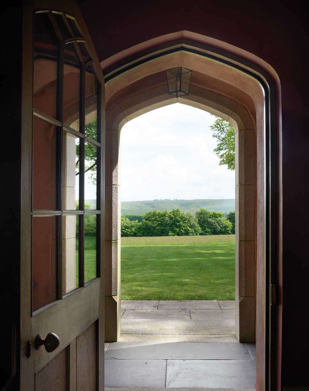 Looking through the front door across the lawn and hay meadow to the Exmoor landscape.