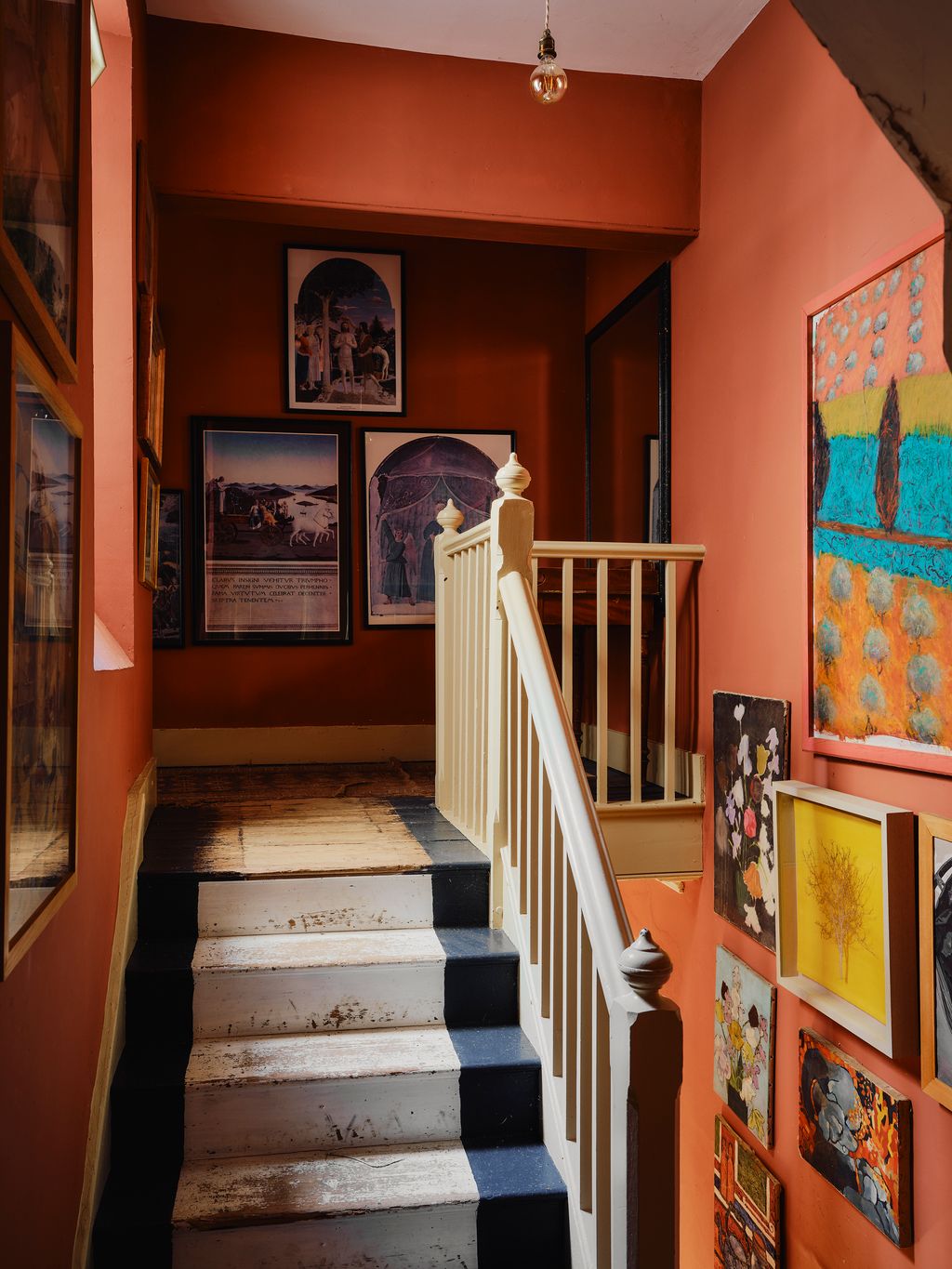 A dense hang of pictures lines the staircase. ‘For me the paintings in a house are central  internal windows of your...