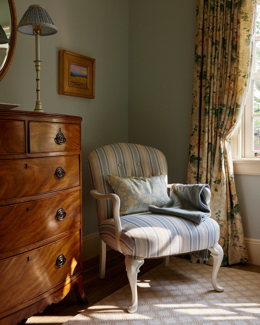 Antique furniture helps add a sense of accumulated history to the guest bedroom in this charming new build. The chair is...