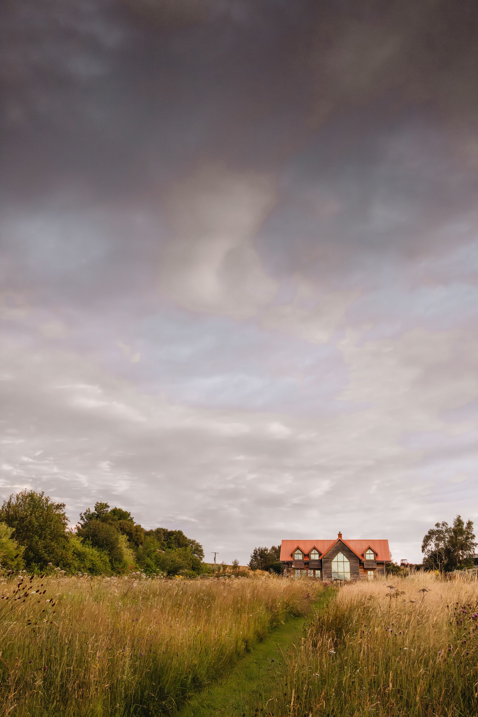 The couples home seen from the meadow at the bottom of the main borders. Built from timber and local stone it references...