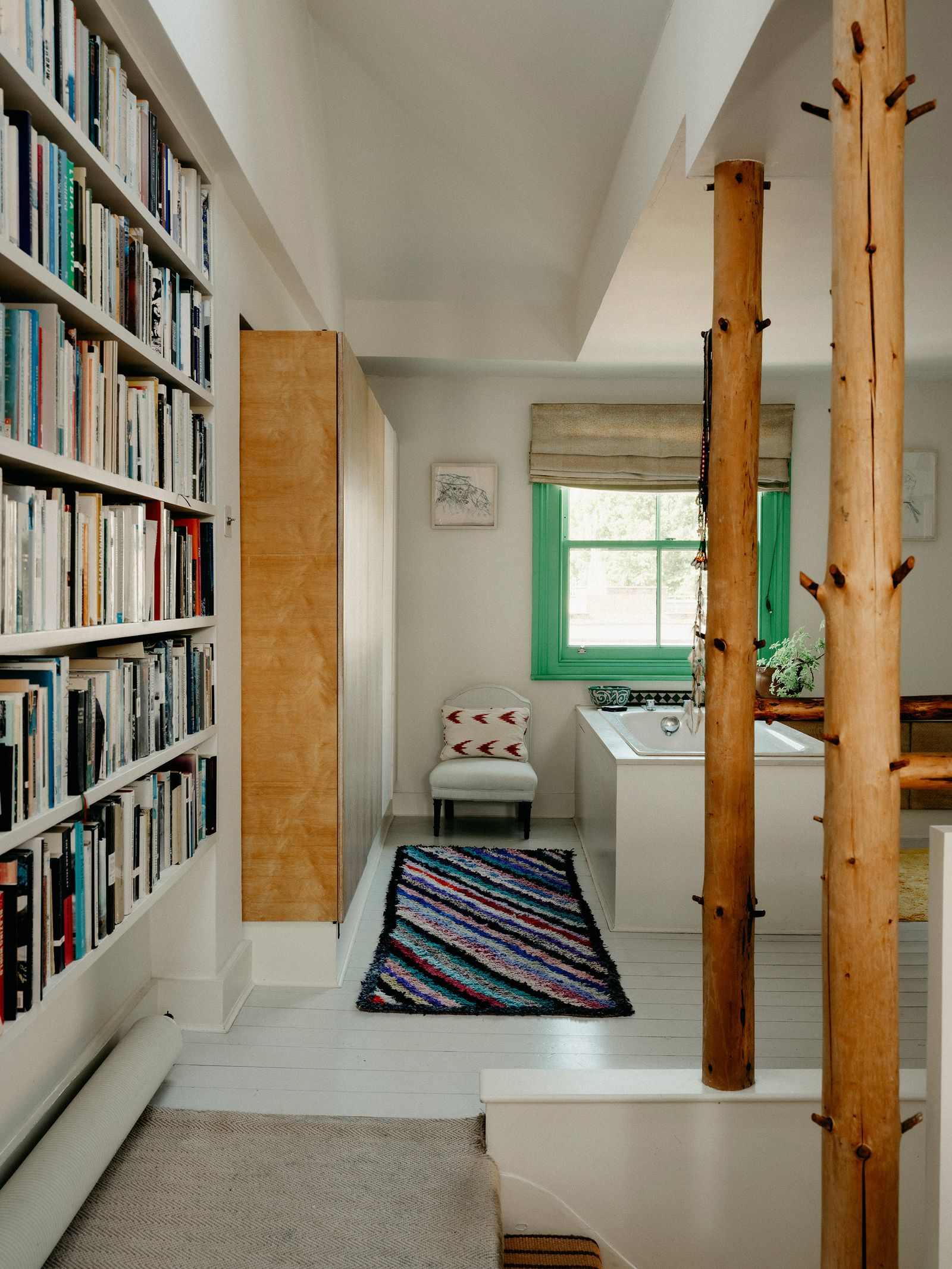 On the top floor of her London home artist Tarka Kings introduced wooden poles  on either side of the staircase to...