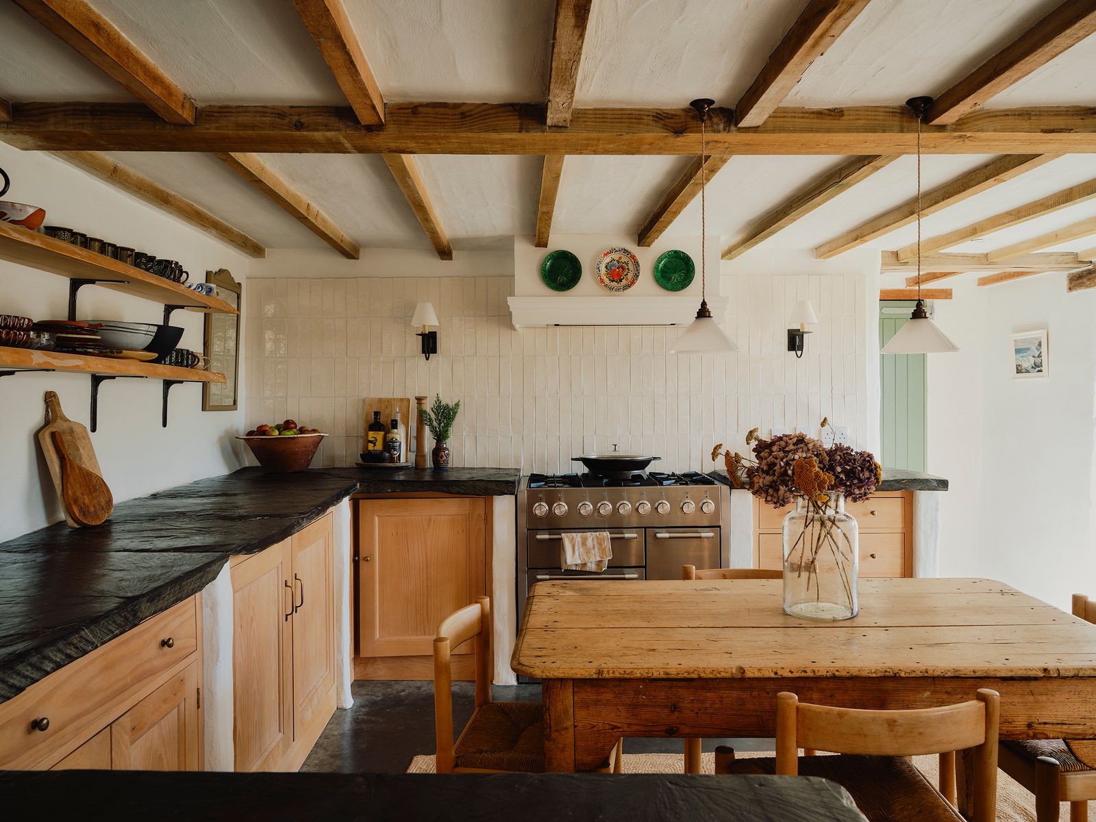 The walls are painted a matte pure white by Lakeland Paints. The pendants above the table are from Fritz Fryer and the...