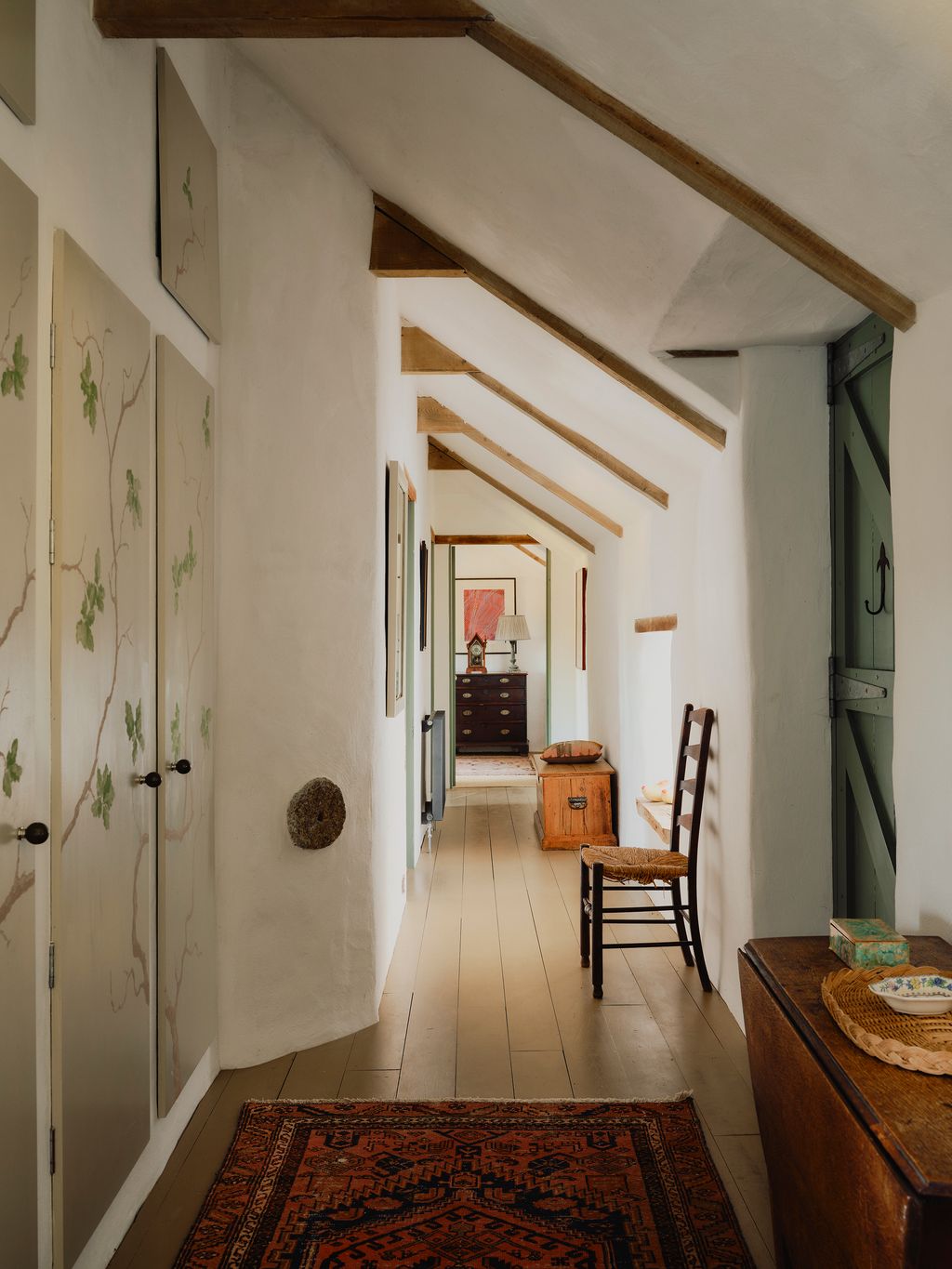 The cupboards pictured store all of the familys coats and shoes. The doors were handpainted by Hannah in a design...