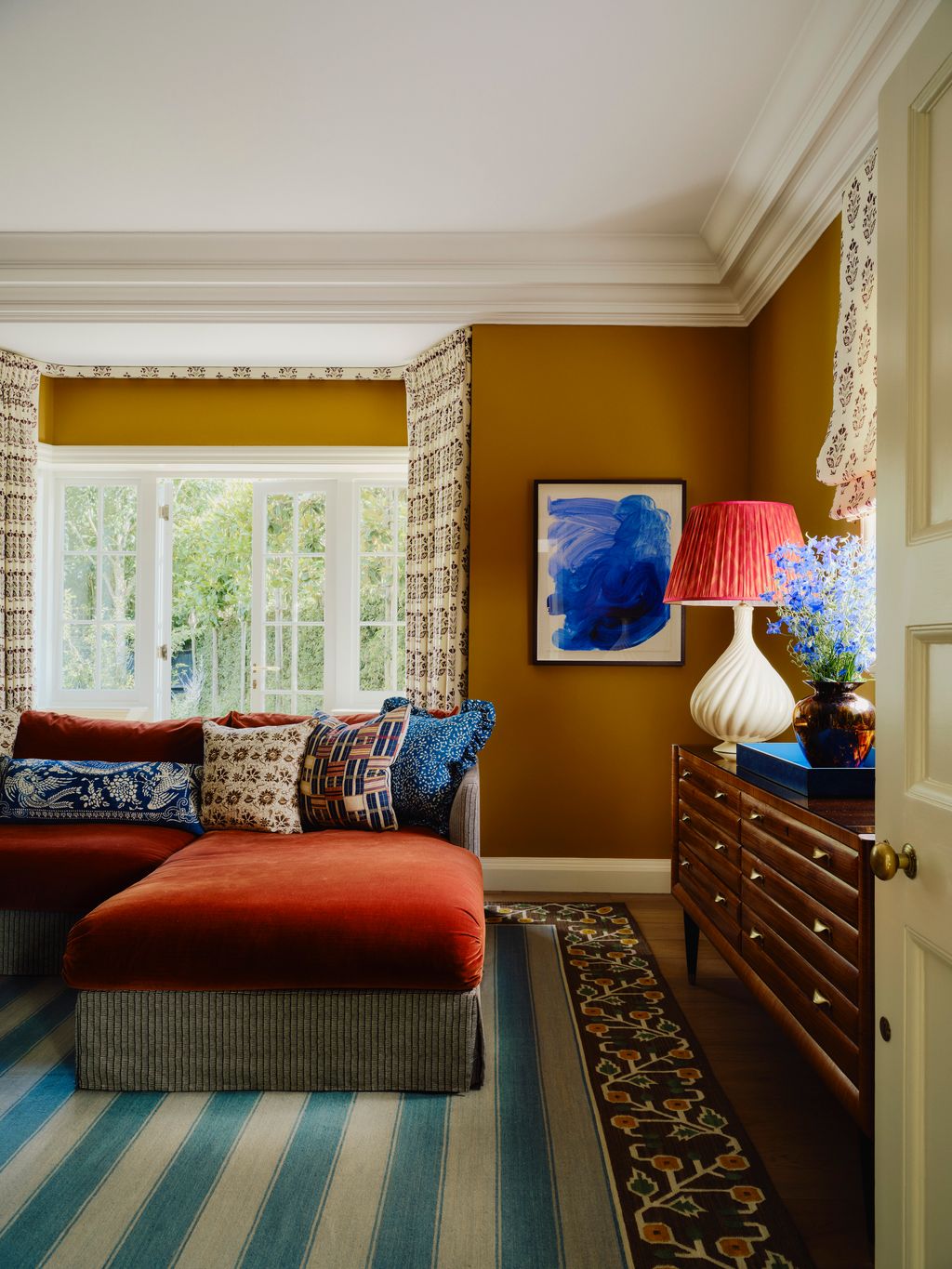 ‘That bright blue painting works beautifully against the mustardyellow walls says Sarah. ‘We definitely had that...