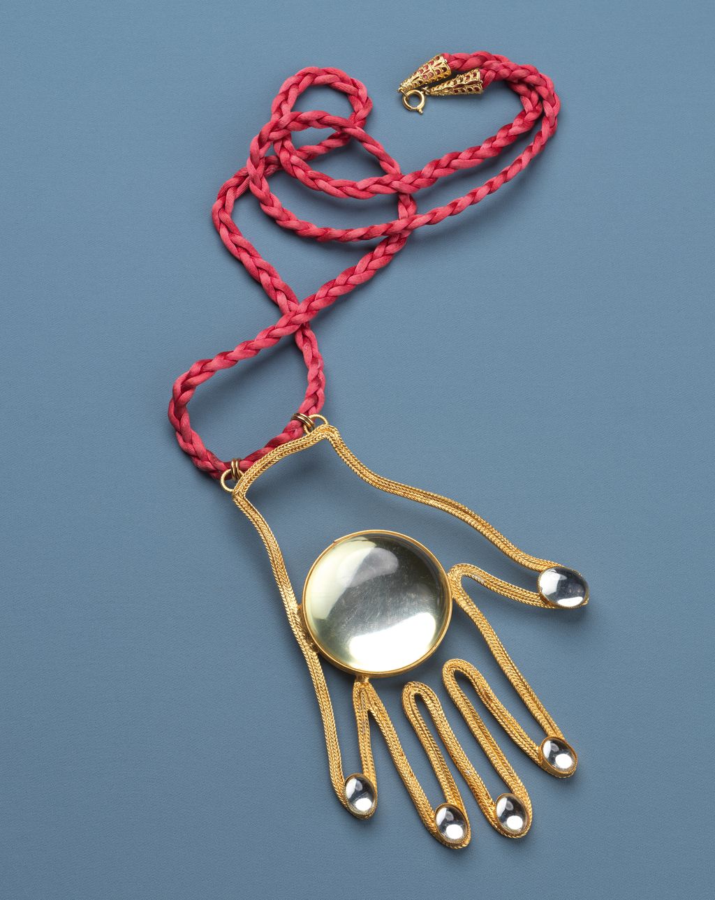 Created in 1971 by William de Lillo this silk necklace features a goldplated pendant in the outline of a hand  a surreal...