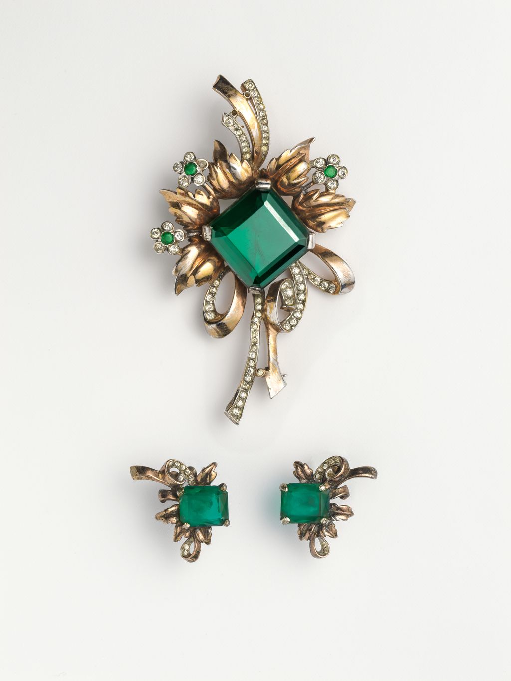 A parure by Rja from the 1940s composed of green crystals and rhinestones set on a golden sterling silver base. The bold...