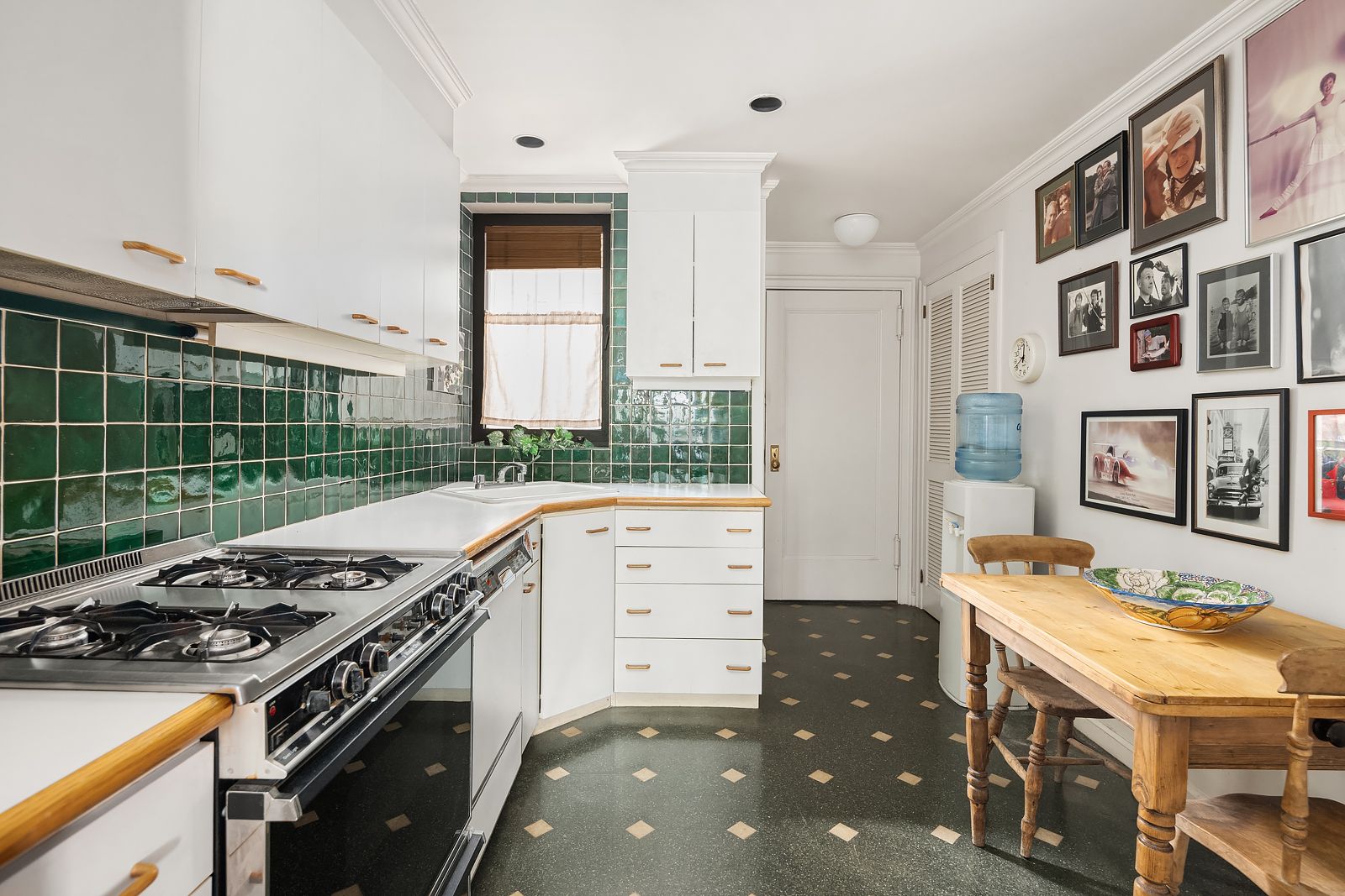 kitchen of Paul Newman and Joanne Woodwards former NYC maisonette with emerald tile backsplash white upper and lower...