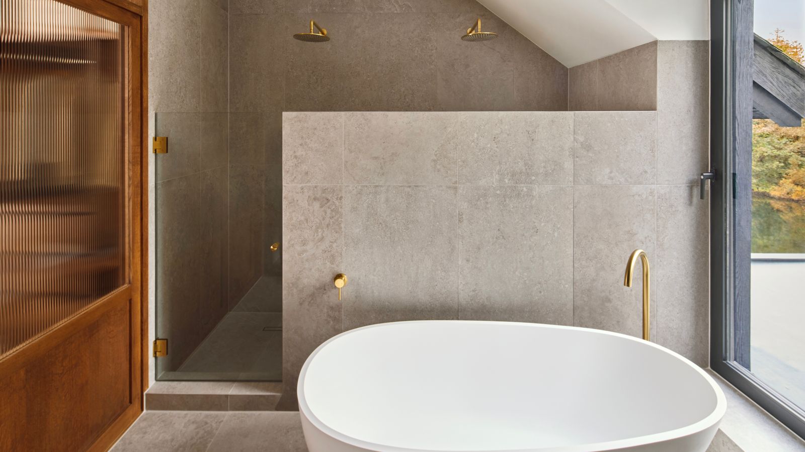 The bathtub in the main ensuite bathroom looks out over the lake and woodland.