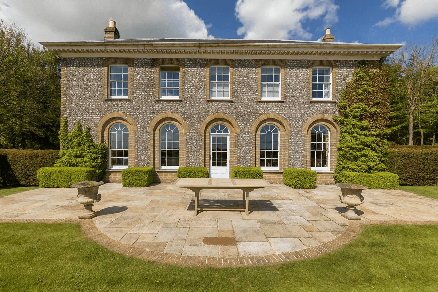 Image may contain: Architecture, Building, Housing, Bench, Furniture, Path, Walkway, Grass, Plant, and House