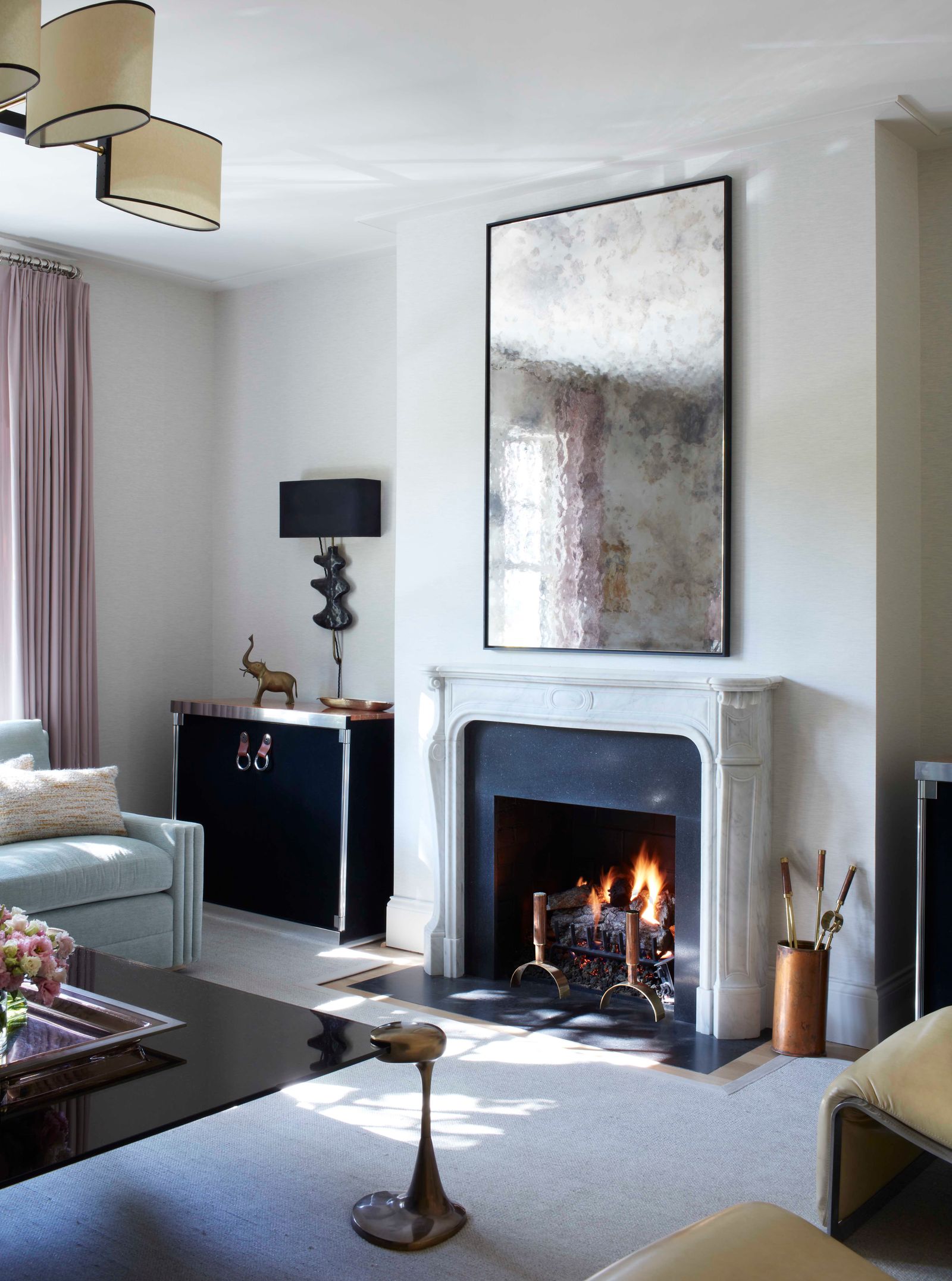 faded white living room decor ideas with antique mirror over fireplace