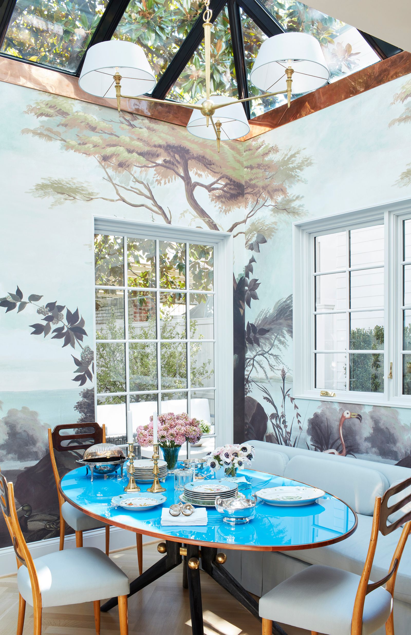period house in Washington DC dining room with walls painted in a forest mural vintage Italian dining table with blue...