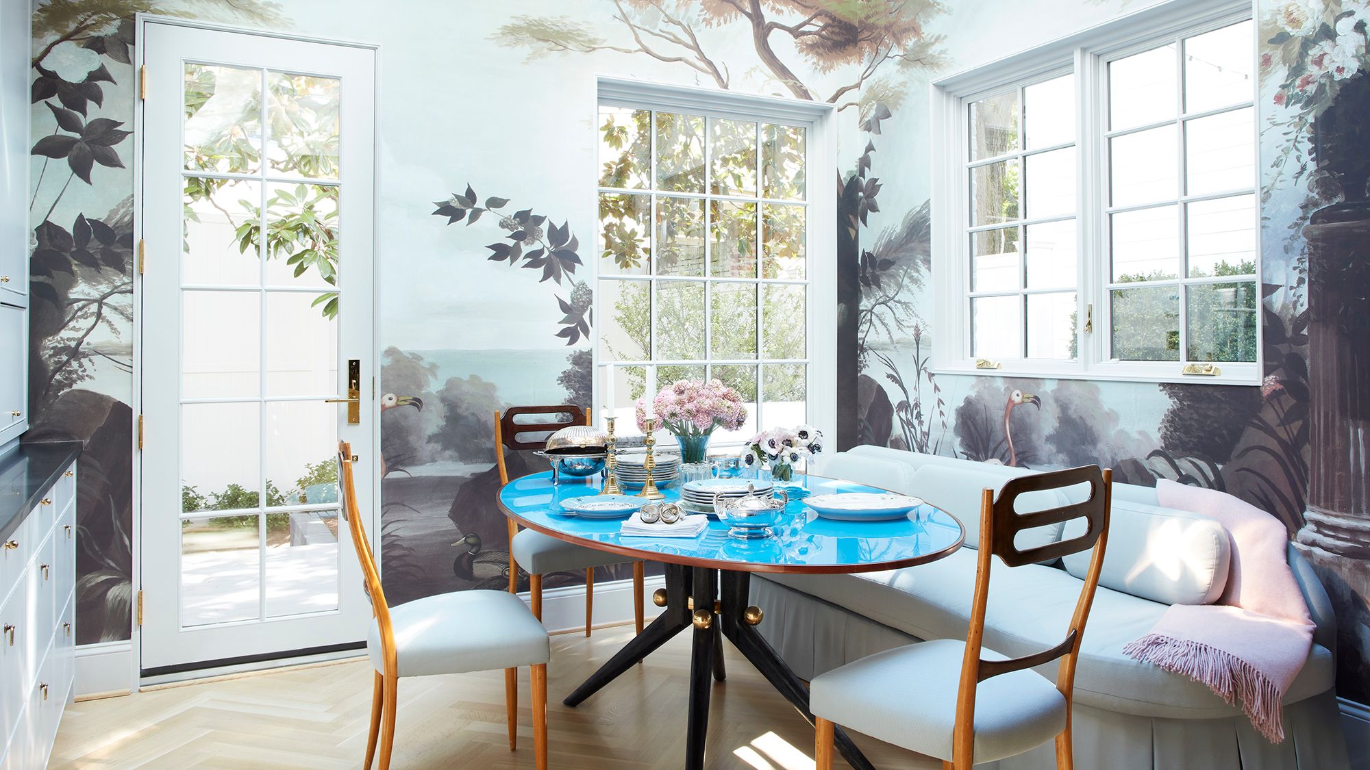 period house in Washington DC dining room with walls painted in a forest mural vintage Italian dining table with blue...